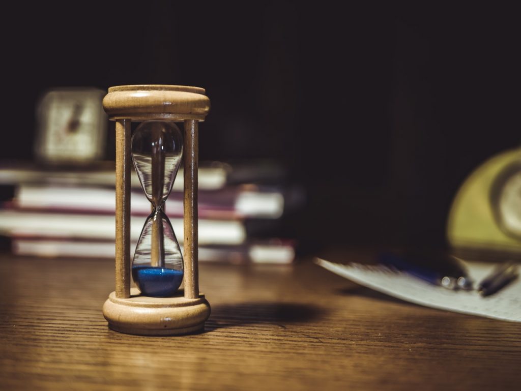 Brown hourglass on brown wooden table