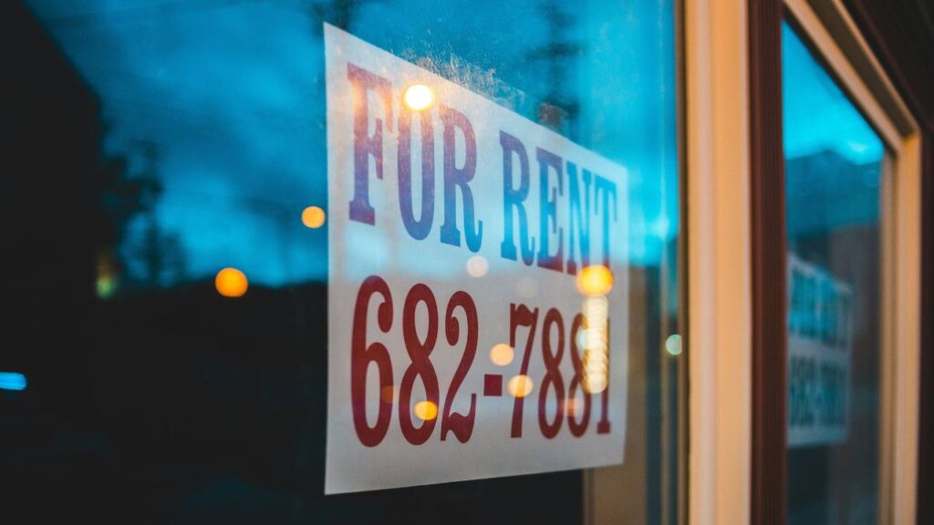 A door sign saying "for rent" and showing a telephone number